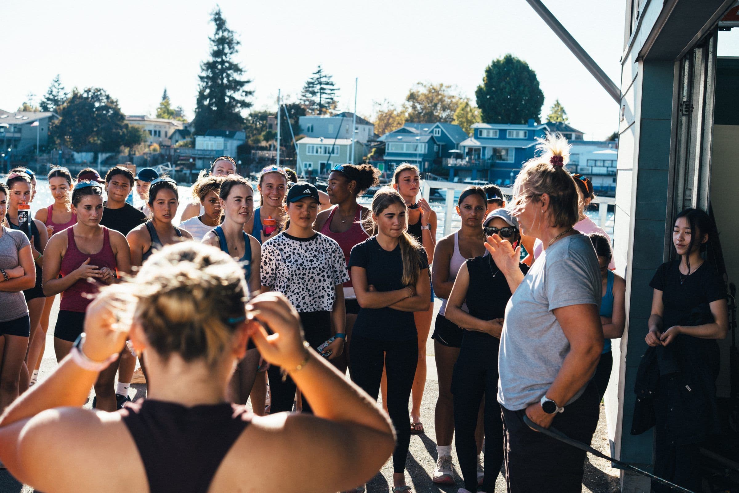 A coach talks to the women's squad outside the boathouse before practice