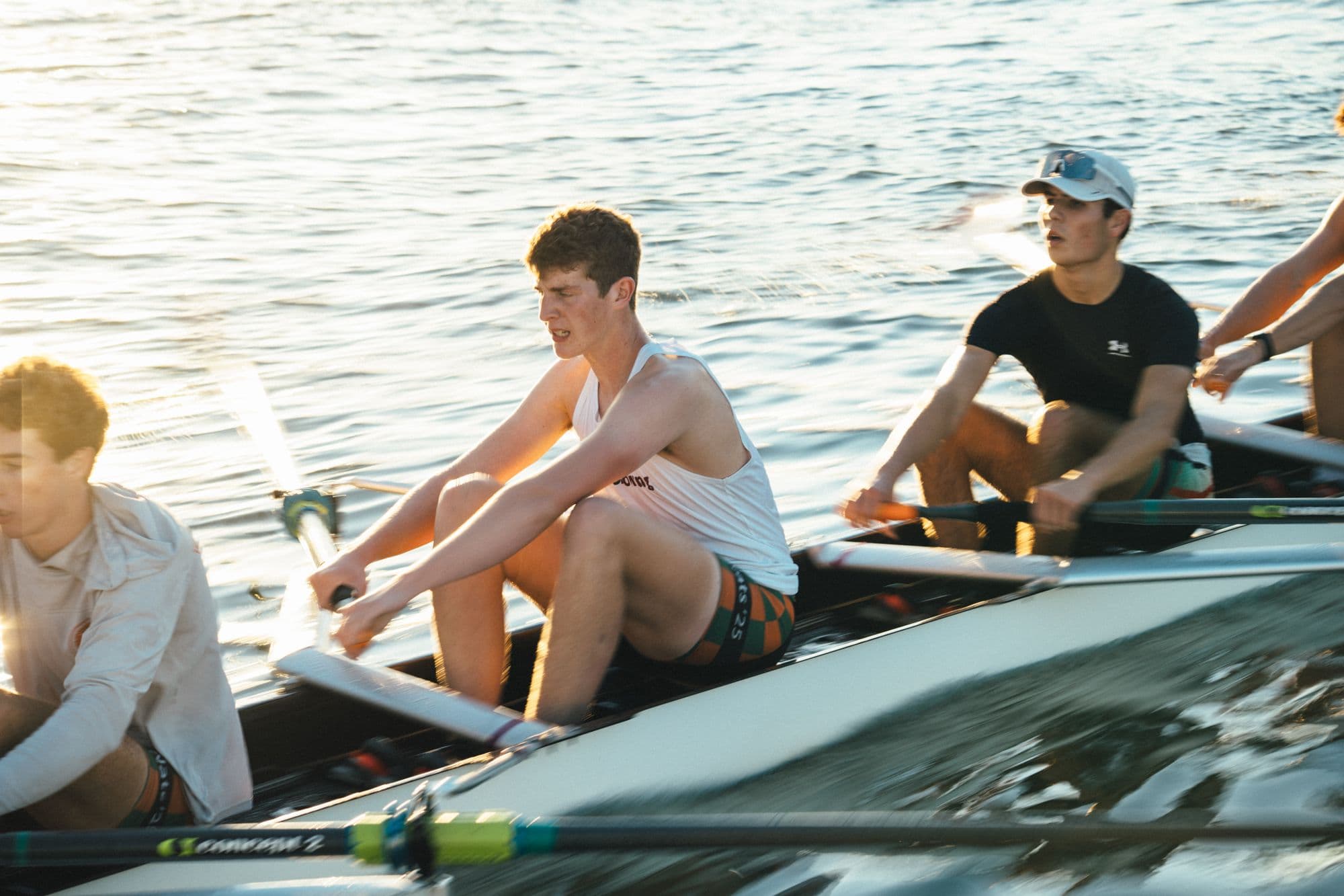 A men's crew rows together in afternoon light at practice on the Estuary